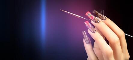 Hand with a beautiful manicure and a brush on a black background. photo
