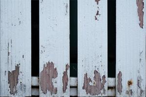 Close-up of weathered, peeling paint on wooden planks. photo