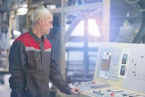 A worker at an enterprise at a computer-controlled machine. photo