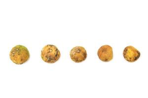 Yellow lemon shows signs of decay with dark spots and shriveled skin, resulting from neglect and bacterial or fungal infection. photo