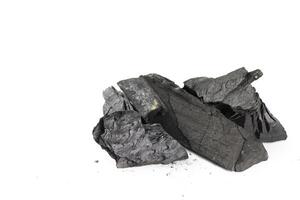 Isolated pieces of black charcoal resting on a clean white background photo