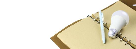 Light bulb on an open notebook, symbolizing creativity, innovation, inspiration and new ideas. photo