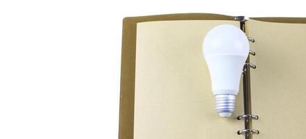 White light bulb on an open notebook, symbolizing creativity, innovation, inspiration and new idea. photo
