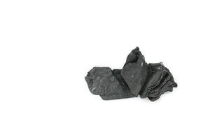 Isolated pieces of black charcoal resting on a white background, showcasing its rough texture and deep, rich color. Often used for grilling, art, and filtration. photo