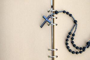 A shiny metal cross rests on brown notebook, symbolizing faith, reflection, and devotion. This image represents spiritual journaling, personal prayers, and religious contemplation. photo