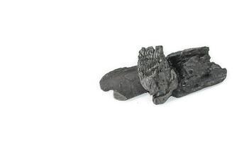 Isolated pieces of black charcoal on a clean white background, showcasing its rough texture and deep, rich color. Often used for grilling, art, and filtration. photo
