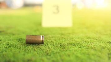 Spent bullet casing in focus, with a blurred forensic number 3 tag behind it, symbolizes crime scene investigation, evidence collection, and law enforcement efforts in forensic science. photo