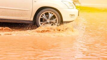 A vehicle navigates through muddy floodwater, depicting urban resilience and the impact of heavy rain. This image highlights extreme weather, climate change. photo