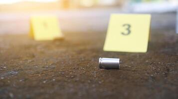 A spent bullet casing in focus, with a blurred forensic number 3 tag behind it, symbolizes crime scene investigation, evidence collection, and law enforcement efforts in forensic science. photo