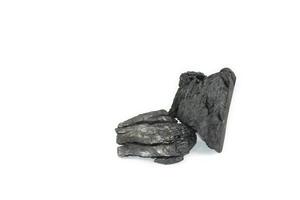 Isolated pieces of black charcoal resting on white background, showcasing its rough texture and deep, rich color. Often used for grilling, art, and filtration. photo