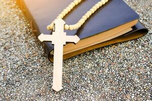 White ivory cross placed on a dark brown notebook reflects purity, peace, and divine guidance. The contrast symbolizes light amidst darkness, faith, and personal devotion. photo