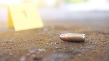 Spent bullet casing in focus, with a blurred forensic number 1 tag behind it, symbolizes crime scene investigation, evidence collection, and law enforcement efforts in forensic science. photo
