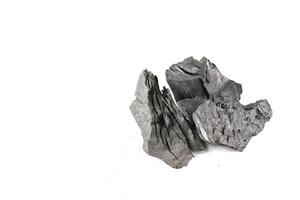 Isolated pieces of black charcoal on a white background, showcasing its rough texture and deep, rich color. Often used for grilling, art, and filtration. photo