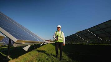 Engineer walking through solar station, checking performance data video