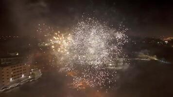 Bright fireworks exploding over a city at night, Large colorful fireworks lighting up the sky above the city video