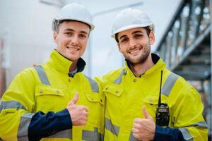 Happy construction workers on site give thumbs up while wearing safety gear and helmets photo