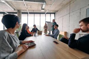 A diverse multiethnic business team engages in a collaborative meeting, discussing strategies and solutions in a modern office setting photo