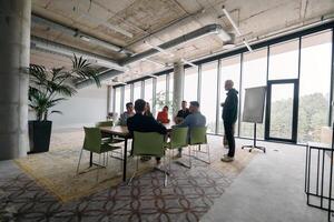 A diverse multiethnic business team engages in a collaborative meeting, discussing strategies and solutions in a modern office setting photo