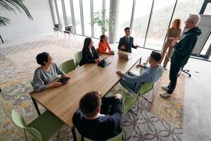 A diverse multiethnic business team engages in a collaborative meeting, discussing strategies and solutions in a modern office setting photo