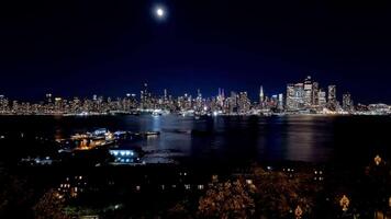 Time-lapse of Manhattan skyline glowing under moonlight, reflected on the Hudson River, Iconic Manhattan skyline captured in a time-lapse, with moonlight reflecting on the Hudson River. video