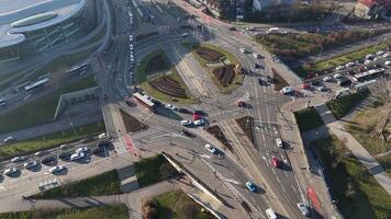 Aerial view of a large traffic roundabout with multiple lanes and tram tracks in Krakow, Complex roundabout with cars, buses, and trams navigating a multi-lane intersection in Krakow, Poland. video