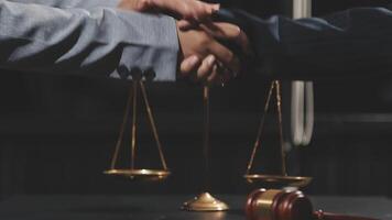 Two lawyers shaking hands over a scale of justice video