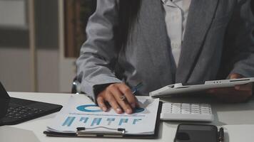 uma mulher dentro uma o negócio terno é trabalhando em uma computador portátil video