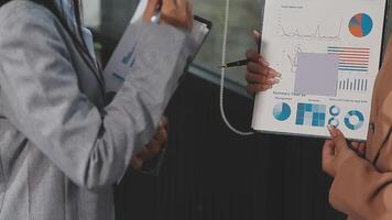 Two business people are holding a clipboard with graphs and charts video
