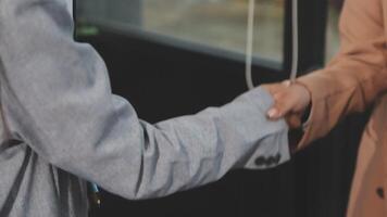 Two people shaking hands in front of a window video