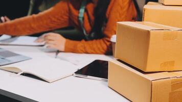 A woman is working on her laptop while sitting in front of a stack of boxes video