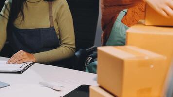 A woman is working on a laptop while holding a box video