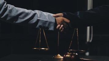 Two business people shaking hands over a scale of justice video