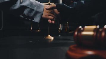 Two people shaking hands over a gavel and scales video