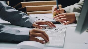 Two people typing on a computer keyboard video