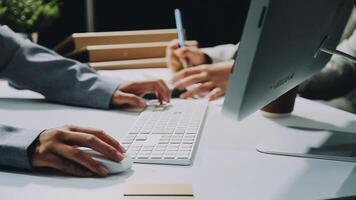 Two people working on a computer at a desk video