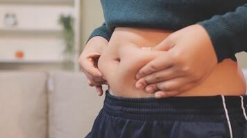A woman is holding her stomach while standing in front of a couch video