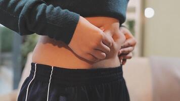 A woman is holding her stomach while standing in front of a couch video