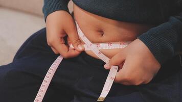 A woman is measuring her stomach with a tape measure video