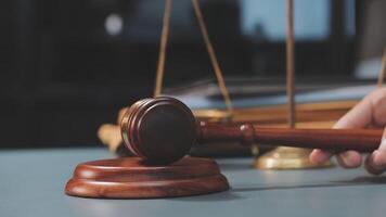 A judge's gavel on a table with a wooden scale video
