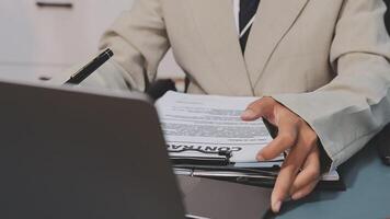 A person in a suit sitting at a desk with a laptop video