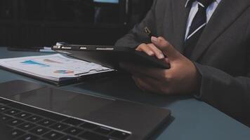 A man in a suit is using a tablet computer video