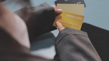 A person holding a credit card in front of a laptop video