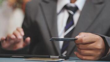 A man in a suit holding a credit card video
