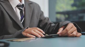 A person in a suit holding a credit card video