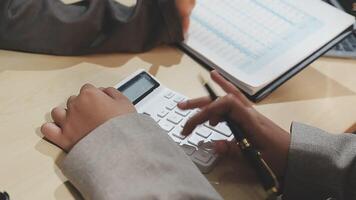 A person is using a calculator to make a financial plan video