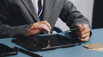 A man in a suit is using a tablet computer video