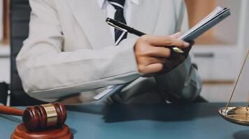 A lawyer writing on a notepad in front of a judge's gavel video
