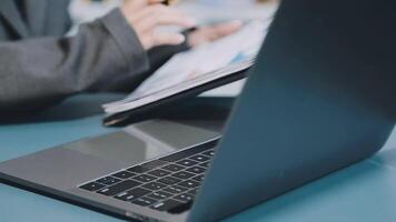 A person in a suit is using a laptop computer video