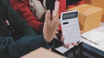 A woman holding a calculator while standing next to boxes video