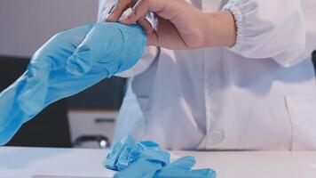 A person in a lab coat is holding a blue glove video